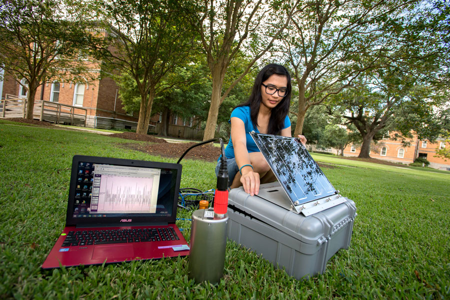 Sarah Oliva, a PhD student in earth and environmental sciences tests a seismometer in the quad near Blessey Hall.
